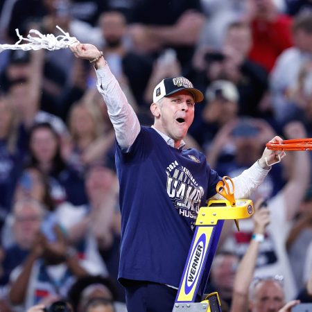 Coach Dan Hurley of the Huskies cuts down the net.