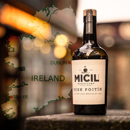 A bottle of Micil Poitín against a blurry background and a map of Ireland