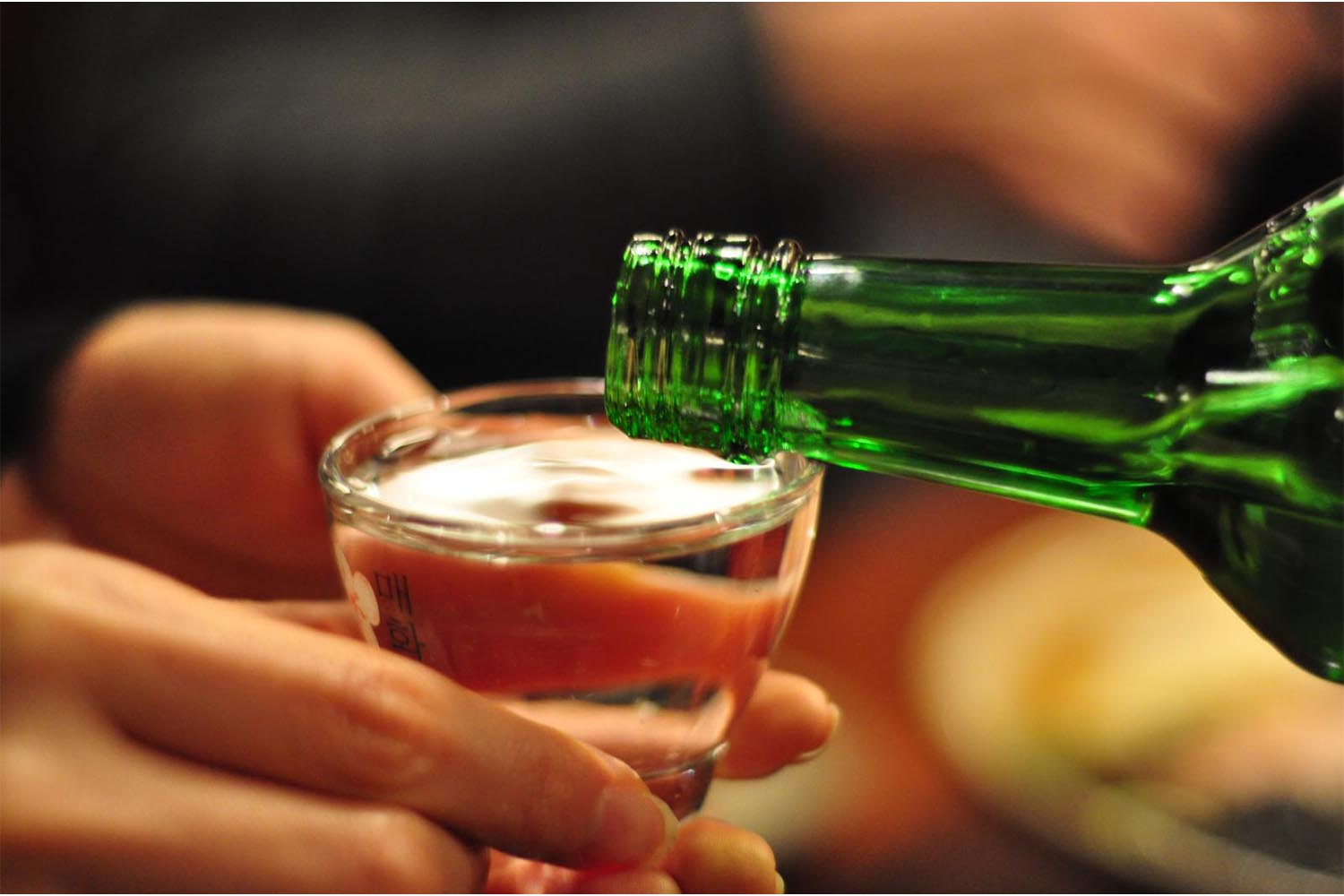 Close-up of soju being poured into a short glass
