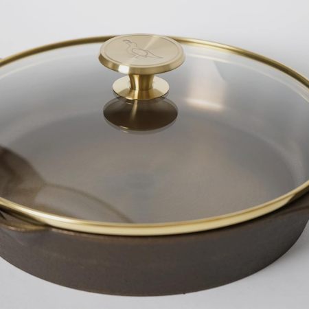 The quail logo on the glass lid of a Smithey cast iron skillet