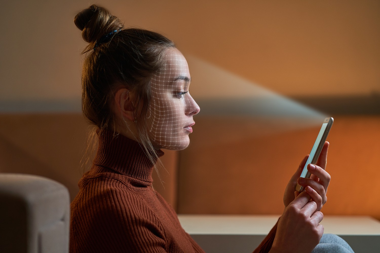 A woman using her selfie camera on her phone to scan her face for facial recognition security measures