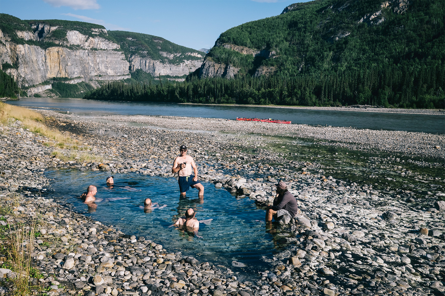 The members of the group relax in a spring by the river.