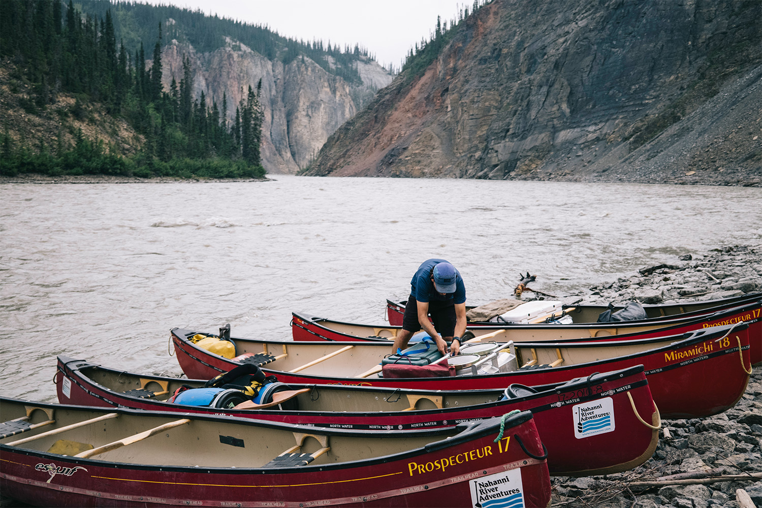 A man loads up the canoes with gear and food.