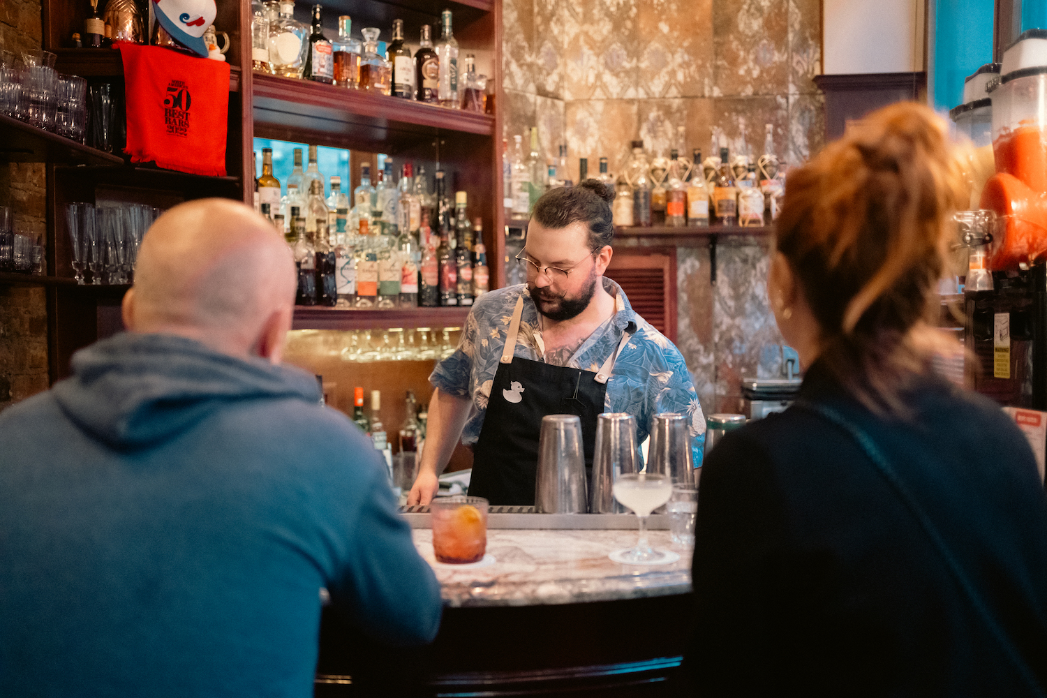 A bartender doing his thing behind the bar at El Pequeno