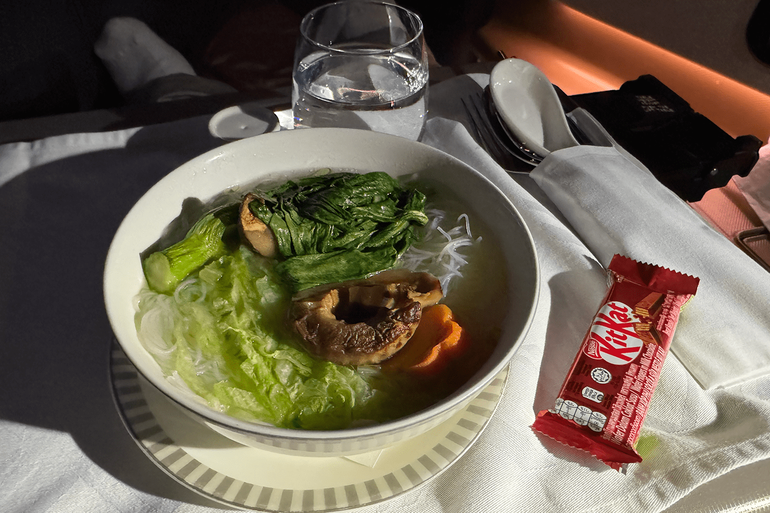 In-flight noodles with greens and mushrooms, and a Kit Kat side