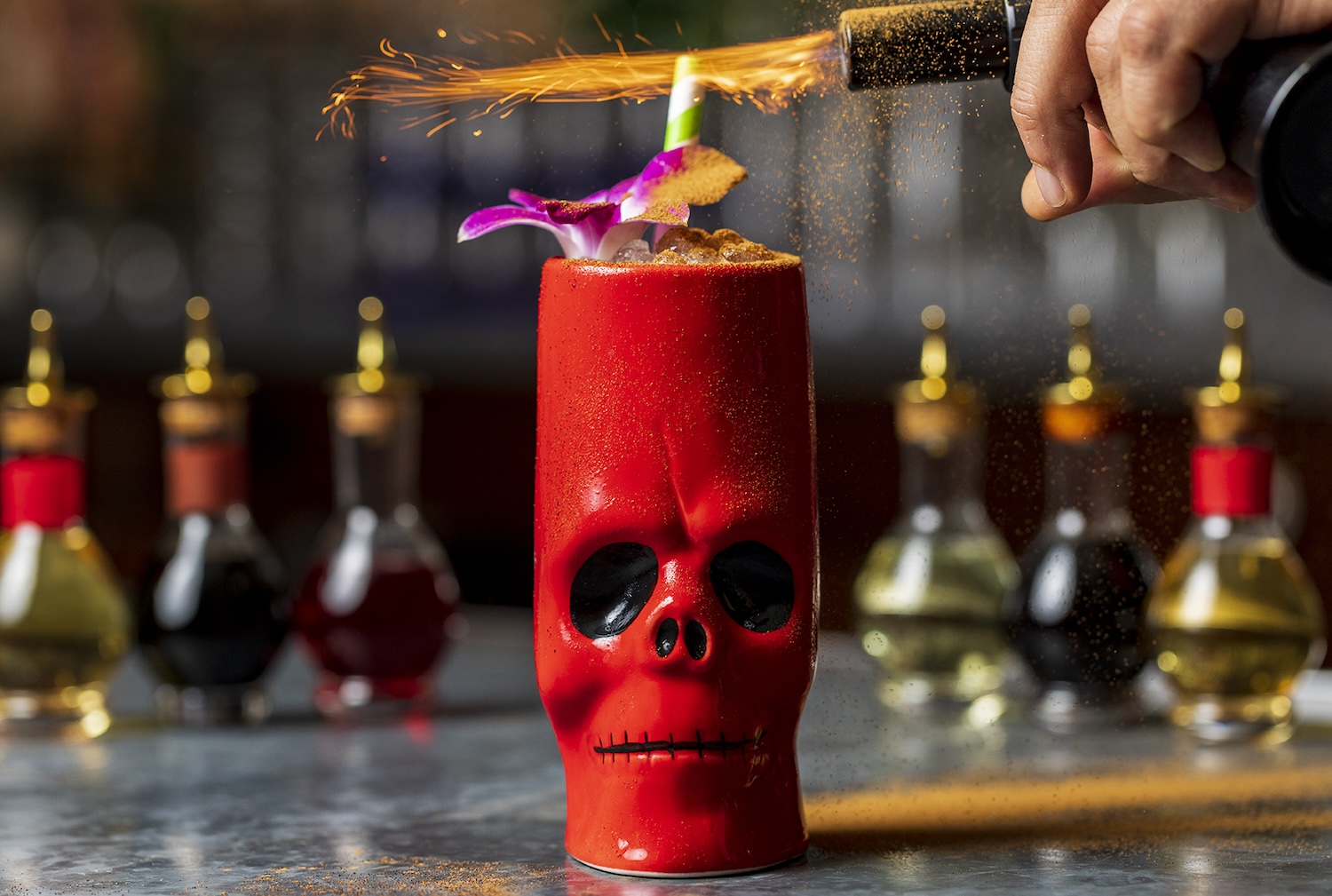 Red skull tiki mug with hibiscus flower on top and getting lit on fire