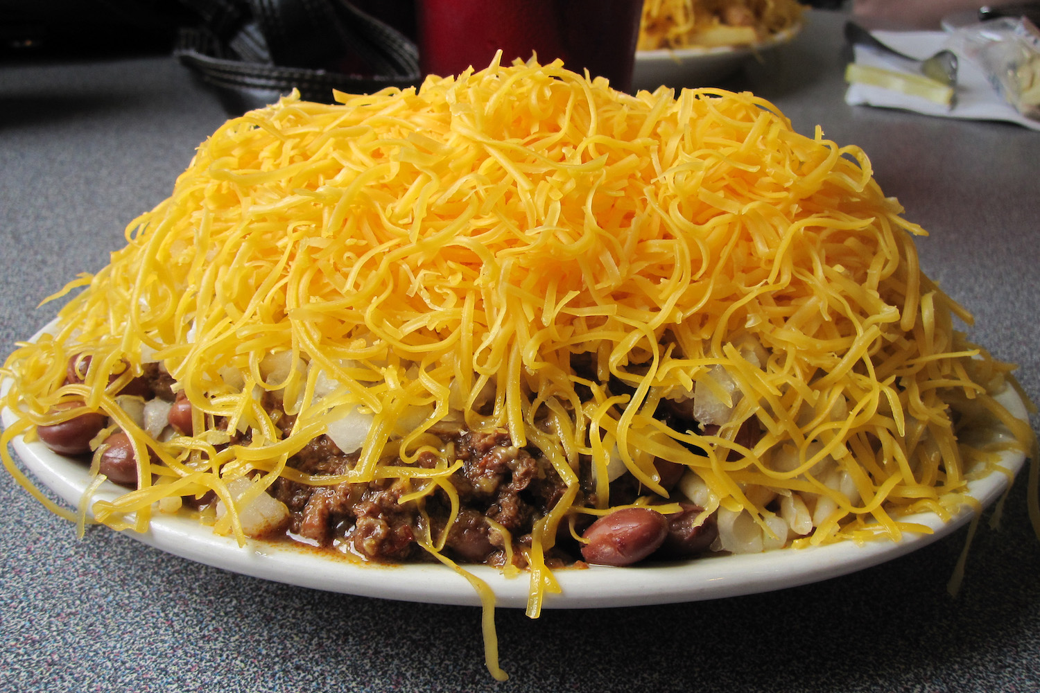 5-Way Chili consists of meats, beans, onions and cheddar cheese on top of spaghetti at Camp Washington Chili in Cincinnati.