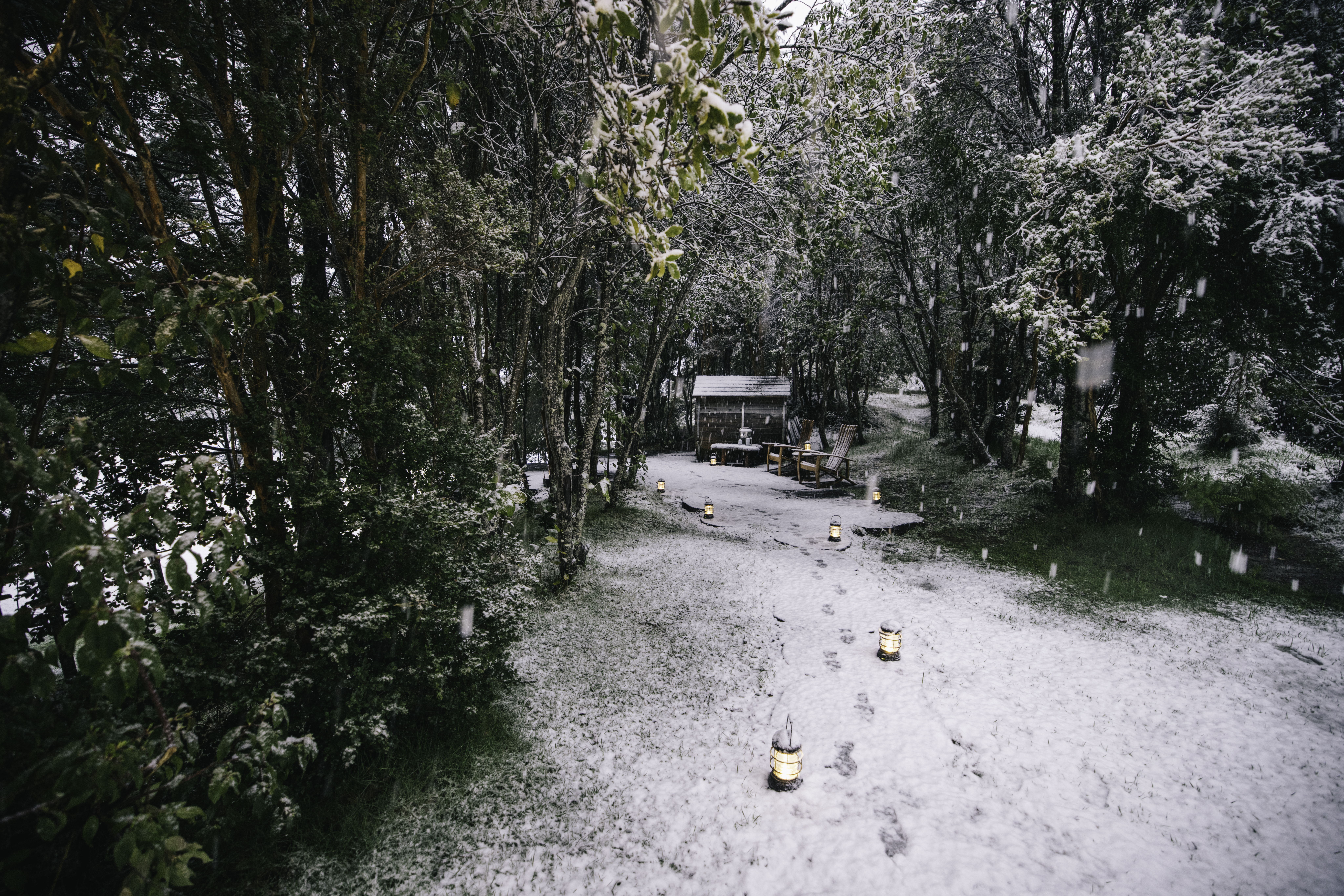 Lanterns and snowprints show the way to an outdoor spa at Rio Palena.