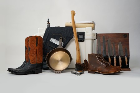 A photo of some of InsideHook's favorite American-made products, including an axe, boots, cast iron skillet, jeans, cooler and knives