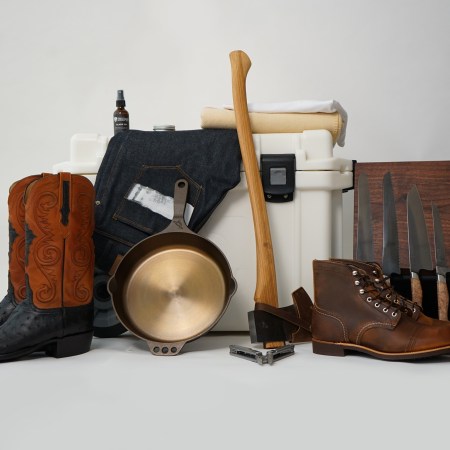 A photo of some of InsideHook's favorite American-made products, including an axe, boots, cast iron skillet, jeans, cooler and knives