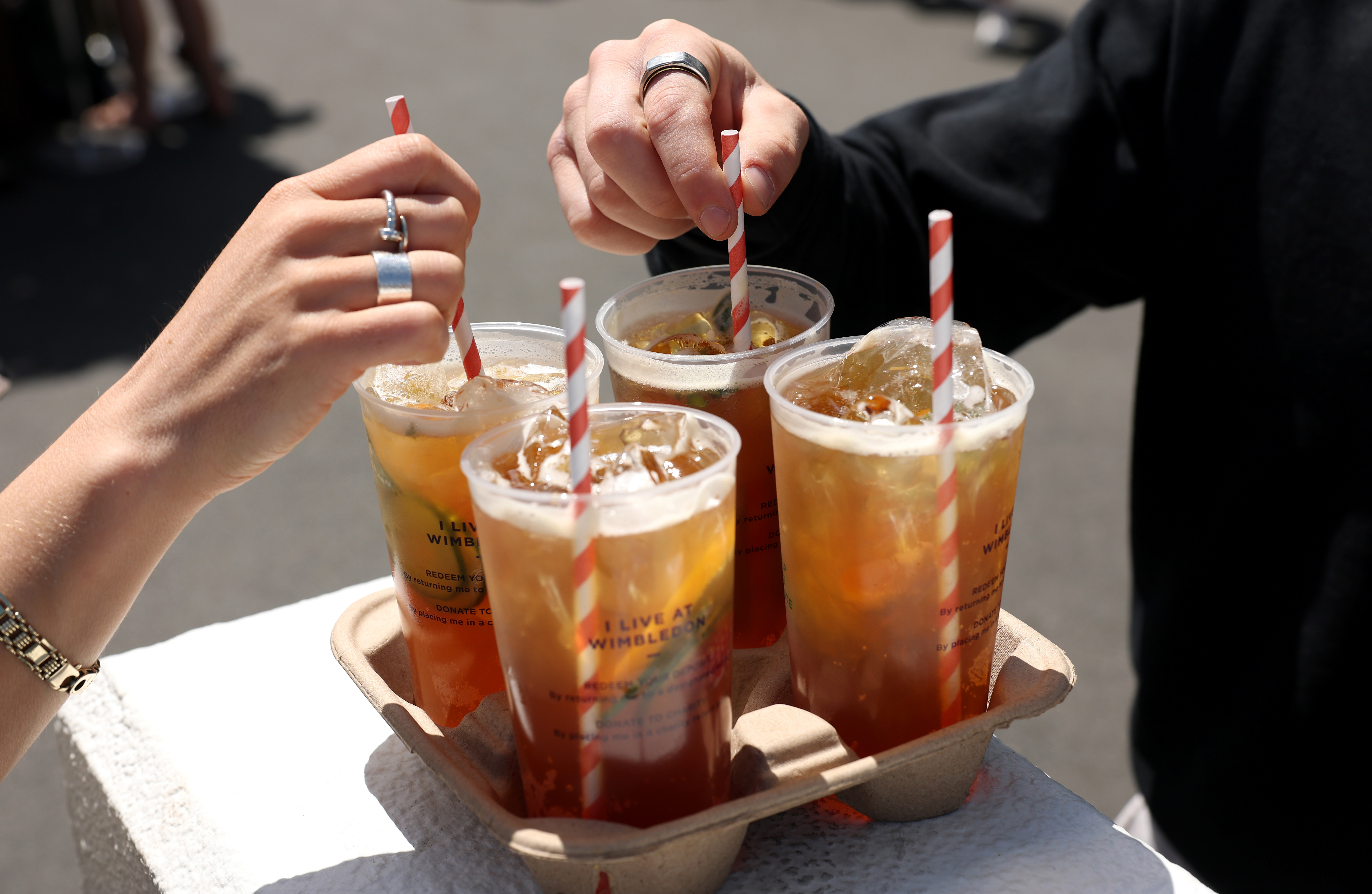Spectators stir their Pimm's during day four of The Championships Wimbledon 2024 at All England Lawn Tennis and Croquet Club