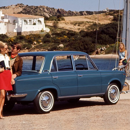 A boy and a girl leaning against a Fiat 125 Berlina. Porto Cervo (Italy)