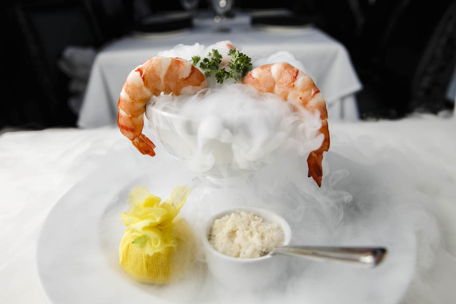 Smoke rises from a bowl (which has dry ice in the bottom) of shrimp cocktail