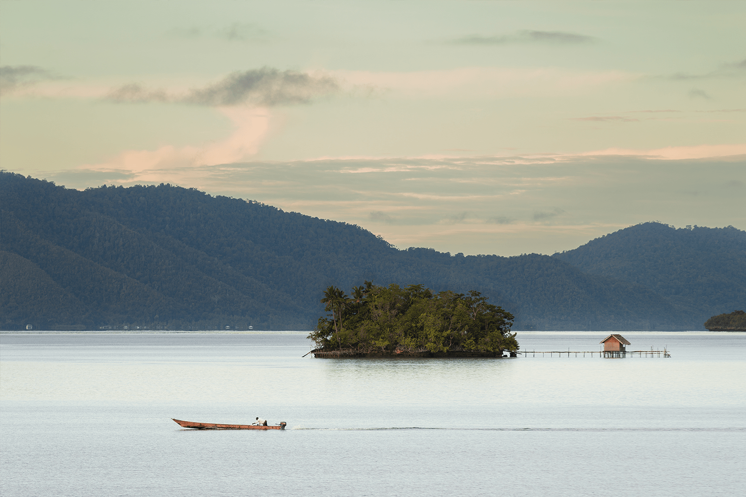 A fisherman passes by an islet near Waigeo
