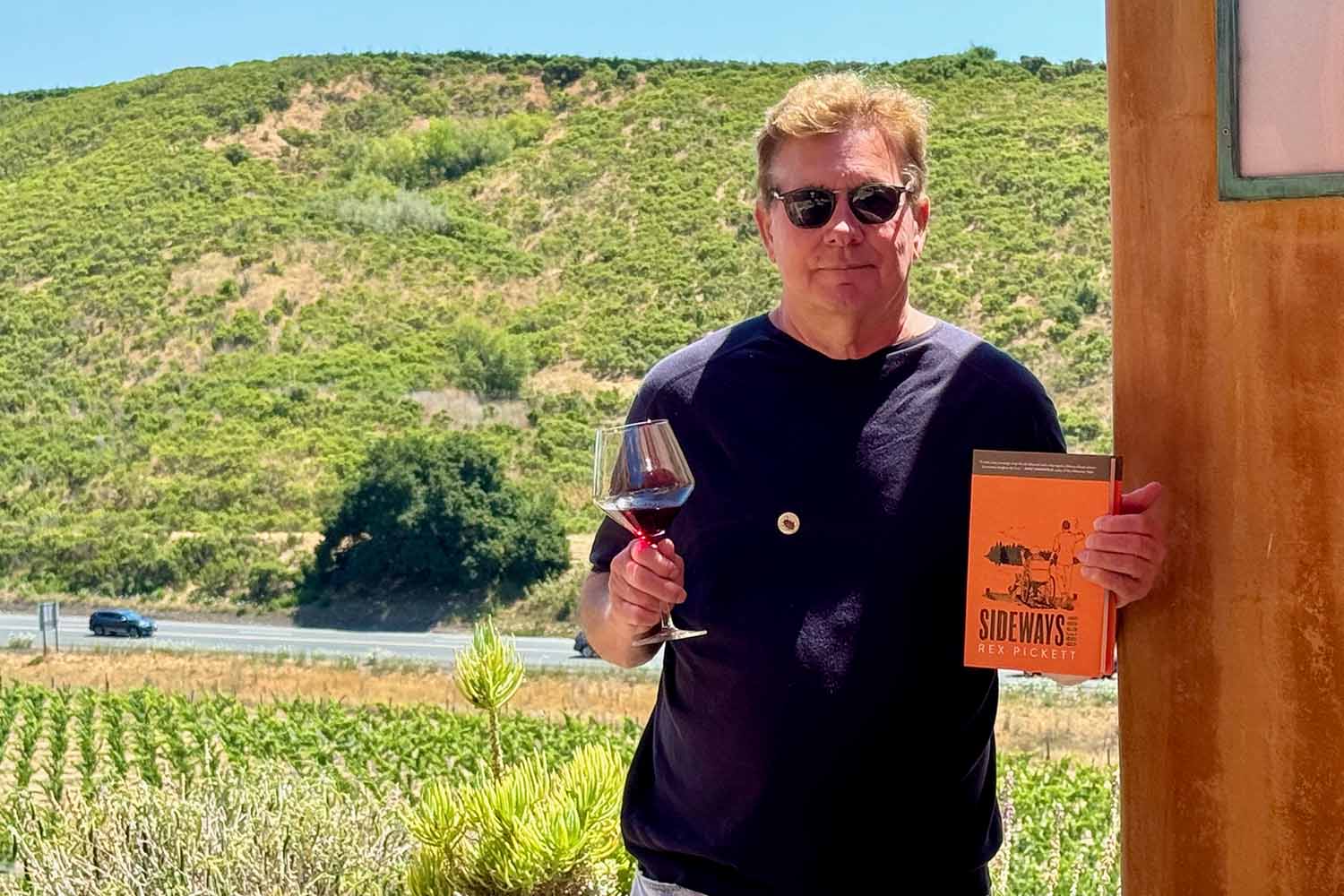 "Sideways" author Rex Pickett, holding his book and a glass of wine