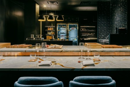 Marble bar with tall blue bar stools at omakase restaurant Bonyeon in Chicago