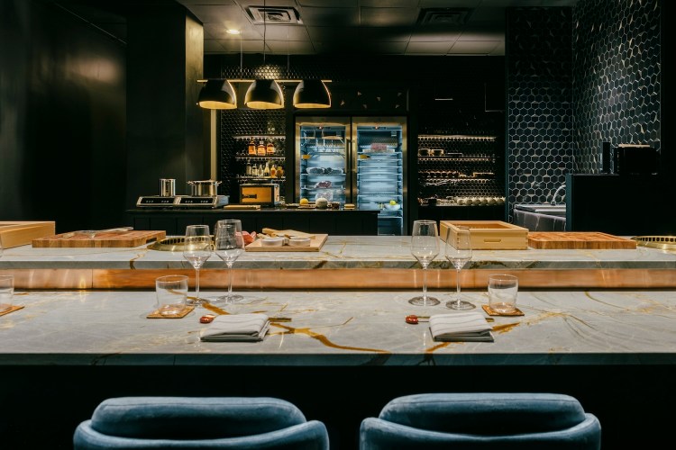 Marble bar with tall blue bar stools at omakase restaurant Bonyeon in Chicago