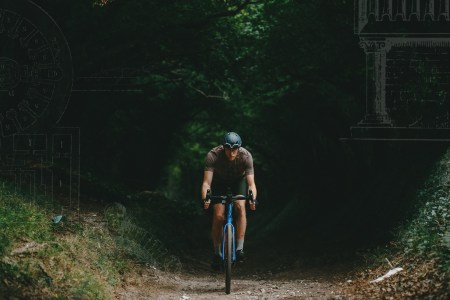 Guy Stapleford emerges from from the trees on a shady trail. Sketches of Roman columns in the corners of the photo.
