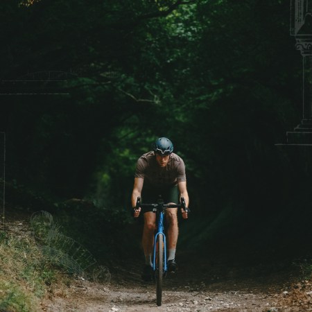 Guy Stapleford emerges from from the trees on a shady trail. Sketches of Roman columns in the corners of the photo.