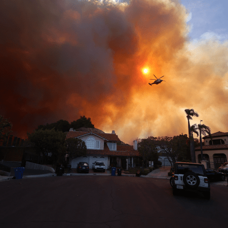 Plumes of smoke are seen as a brush fire burns in Pacific Palisades on Tuesday