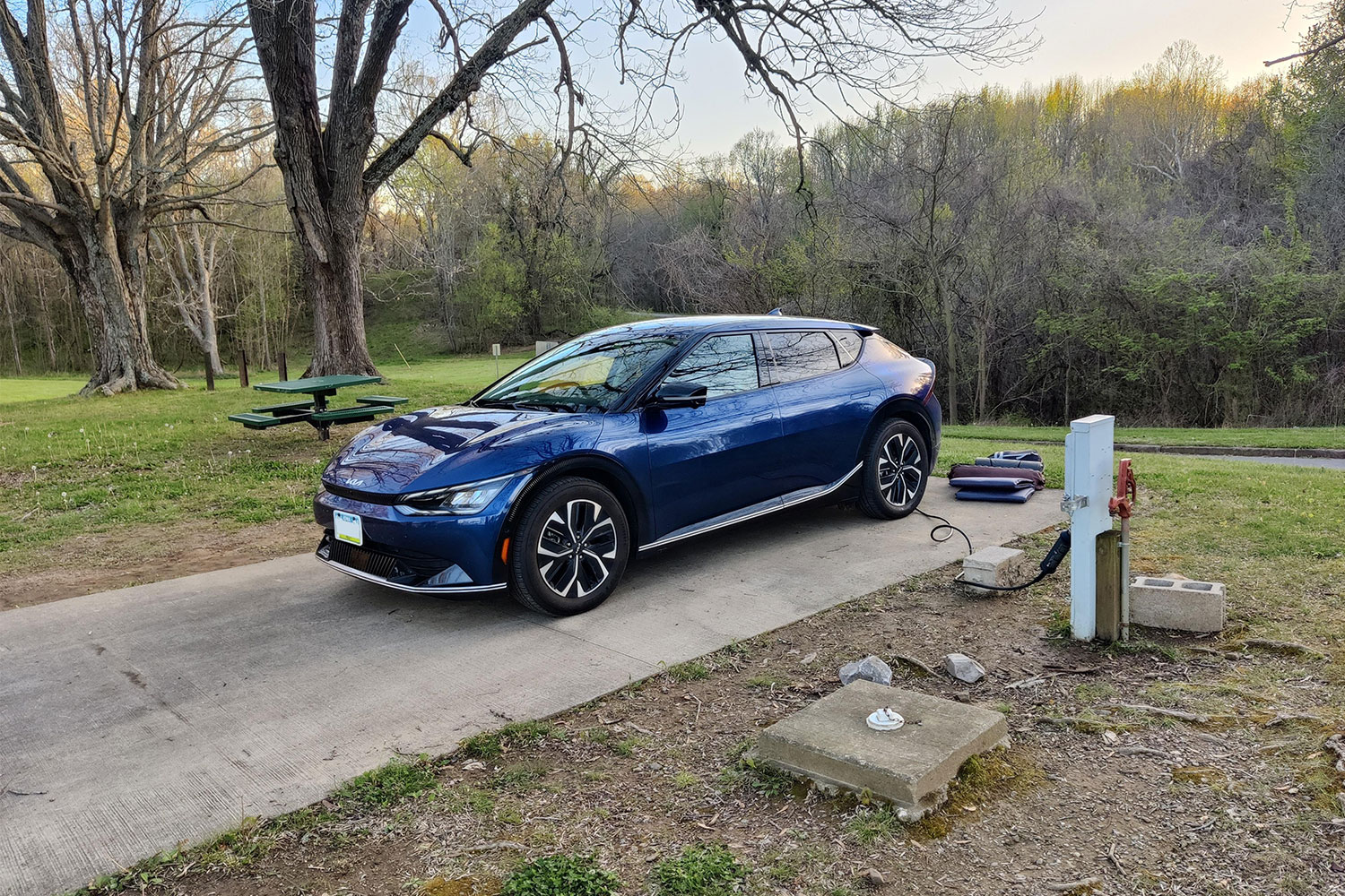 A blue Kia EV charging at a campsite