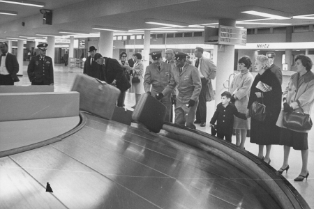 People standing unnecessarily close to the baggage carrousel in 1967