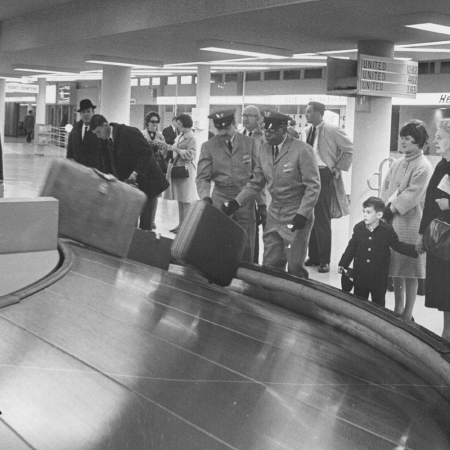 People standing unnecessarily close to the baggage carrousel in 1967