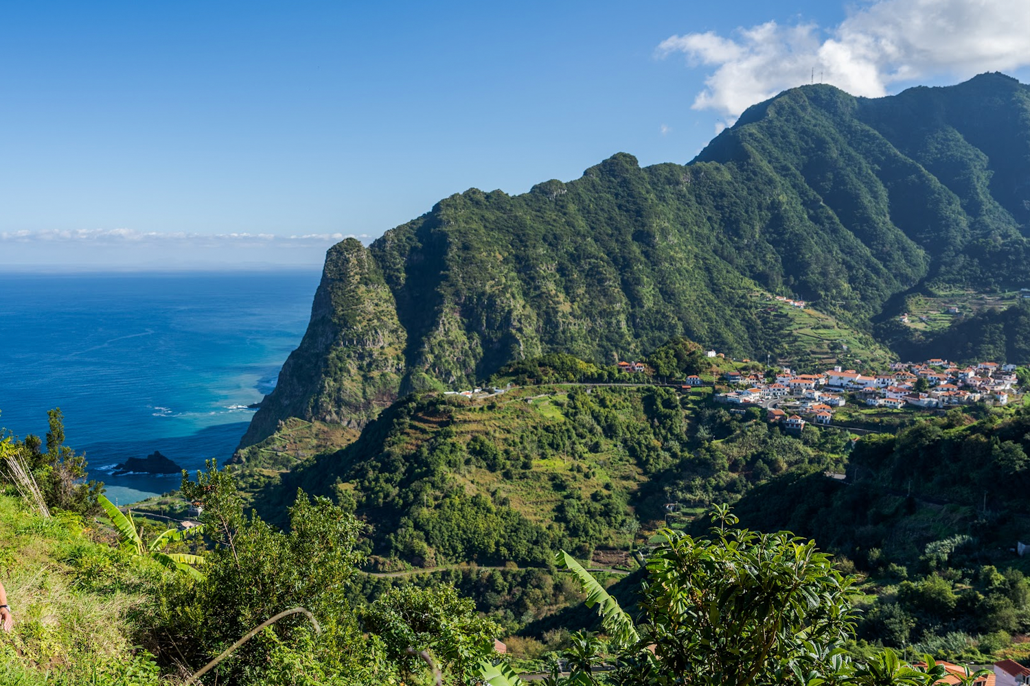 "Where rock faces meet crystalline waters and brightly painted wooden boats anchor in harbors."