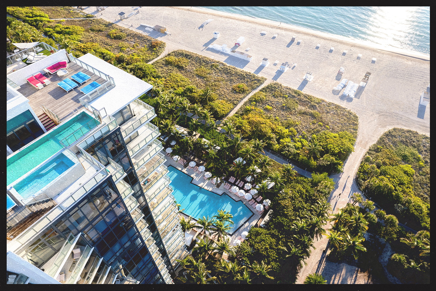 An aerial view of W South Beach showcasing its beachfront access, sparkling pool, and lush greenery.