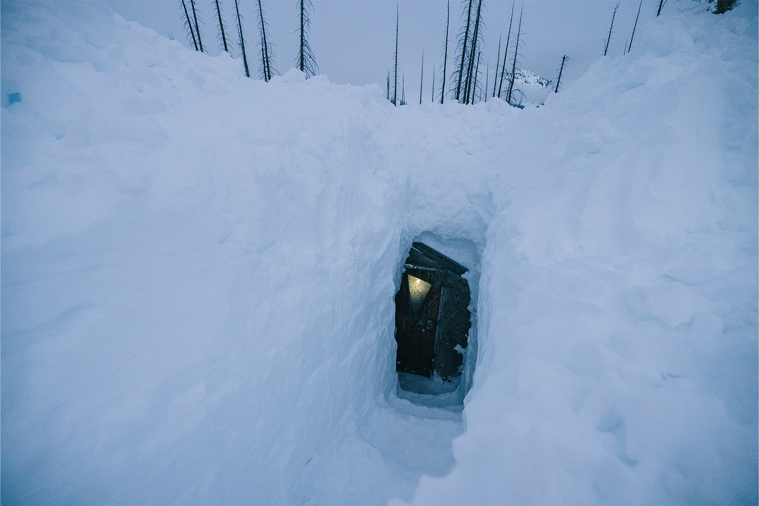 A door to a yurt covered in snow.