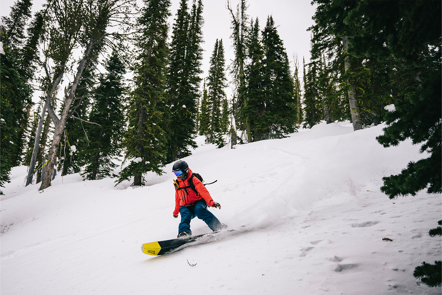 A snowboarder carves against the mountain.