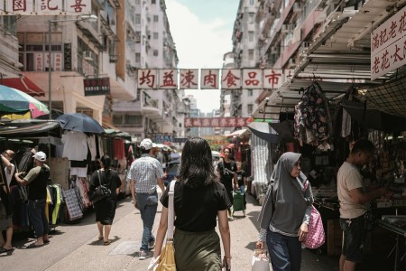 A woman walking down Apliu Street Market in Hong Kong. We take a look at the trend of wanting to "live like a local" when traveling.