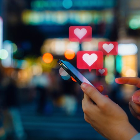 Smartphone user sending love emojis