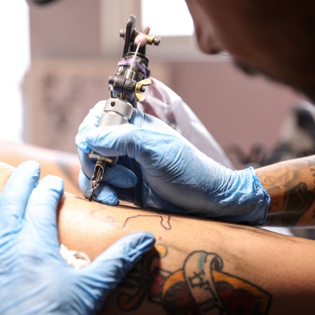 Israel Ortega tattooing a person's leg at a tattoo salon located in the Iztapalapa neighborhood