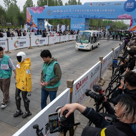 A robot running with two technicians