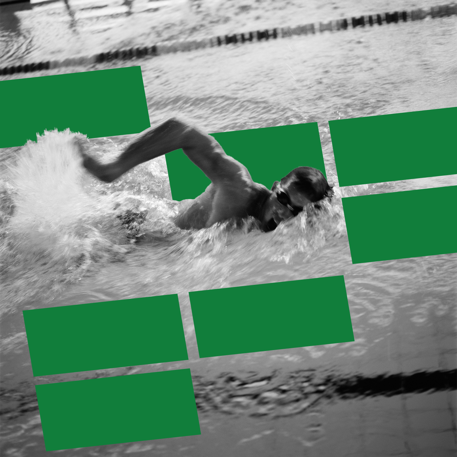 Male swimmer doing freestyle in an indoor lap pool, mid-stroke, with green motion blur on water