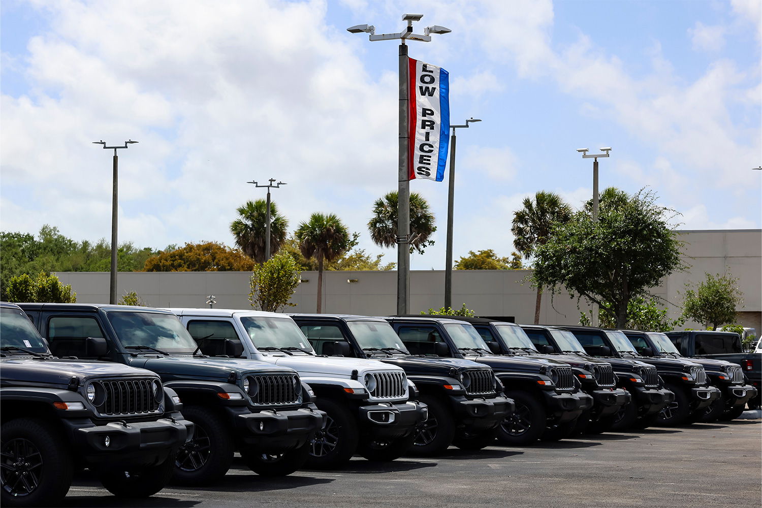 A U.S. car dealership with a flag on a light pole that reads "LOW PRICES." Thanks to Trump's tariffs, the entry-level market may be dealt a killer blow.