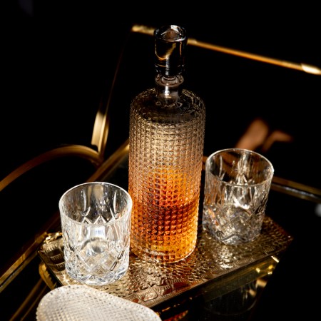 Whisky decanter and two crystal glasses on a brass bar cart