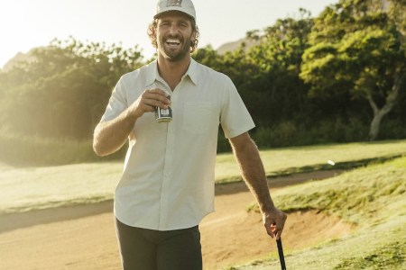 A model playing golf drinking a beer