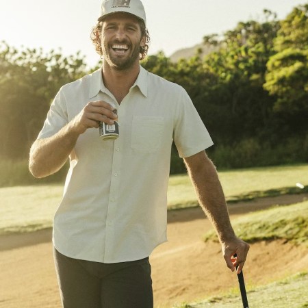 A model playing golf drinking a beer