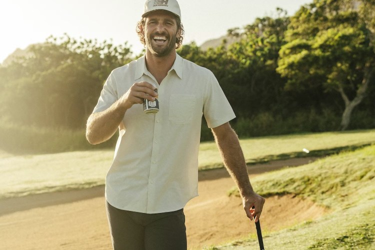A model playing golf drinking a beer