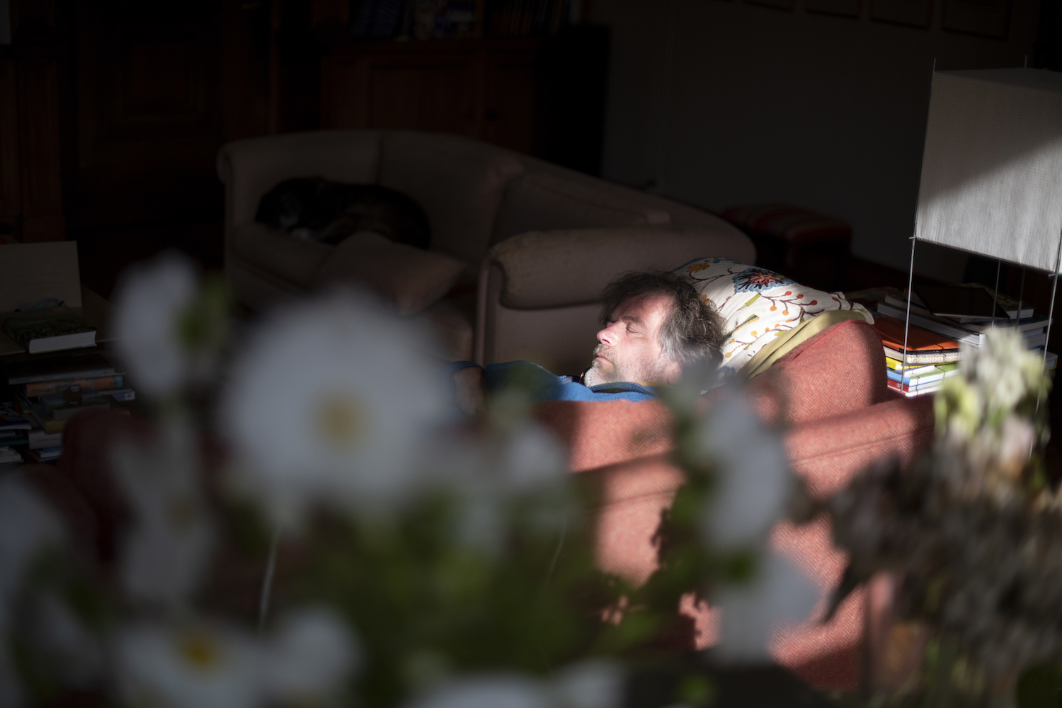 Man sleeping on sofa in his living room. We asked sleep experts about people who have sleep anxiety in a bed, but can sleep fine on a couch.
