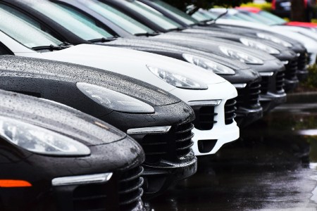 A row of Porsche Macan SUVs in the rain