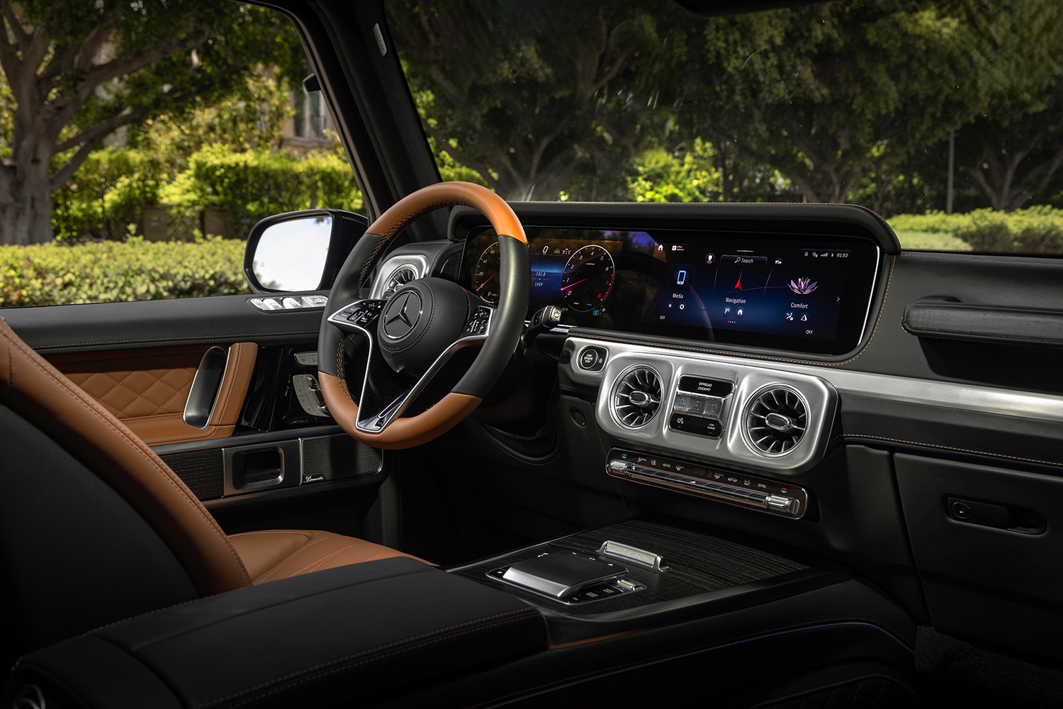 The interior of the 2025 Mercedes-Benz G550 SUV, showing the steering wheel, infotainment cluster and driver's seat