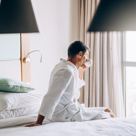 Man drinking coffee in bed