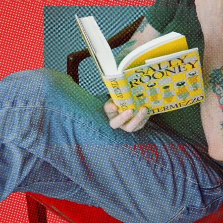 Man lounges reading Sally Rooney's book Intermezzo