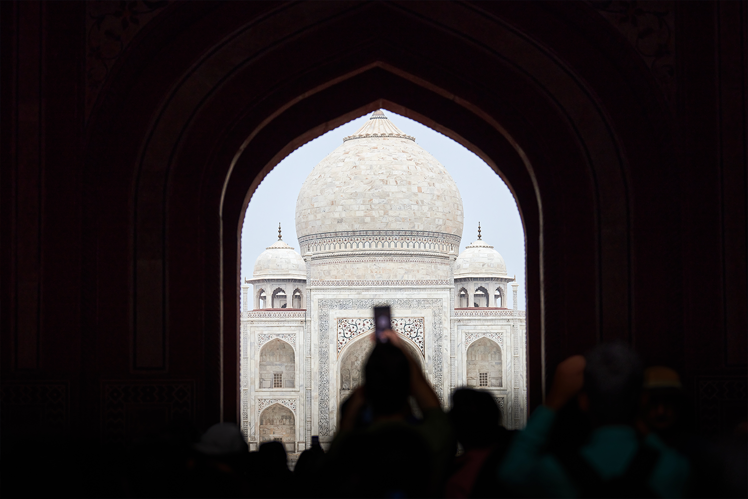 A tourist taking a photo of the Taj Mahal with their camera phone