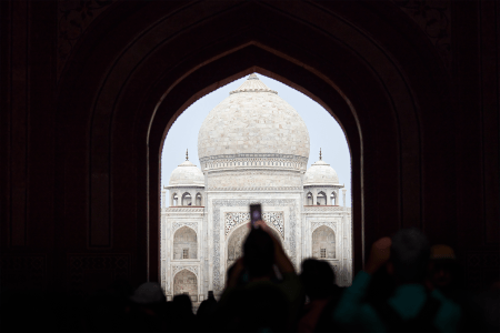 A tourist taking a photo of the Taj Mahal with their camera phone