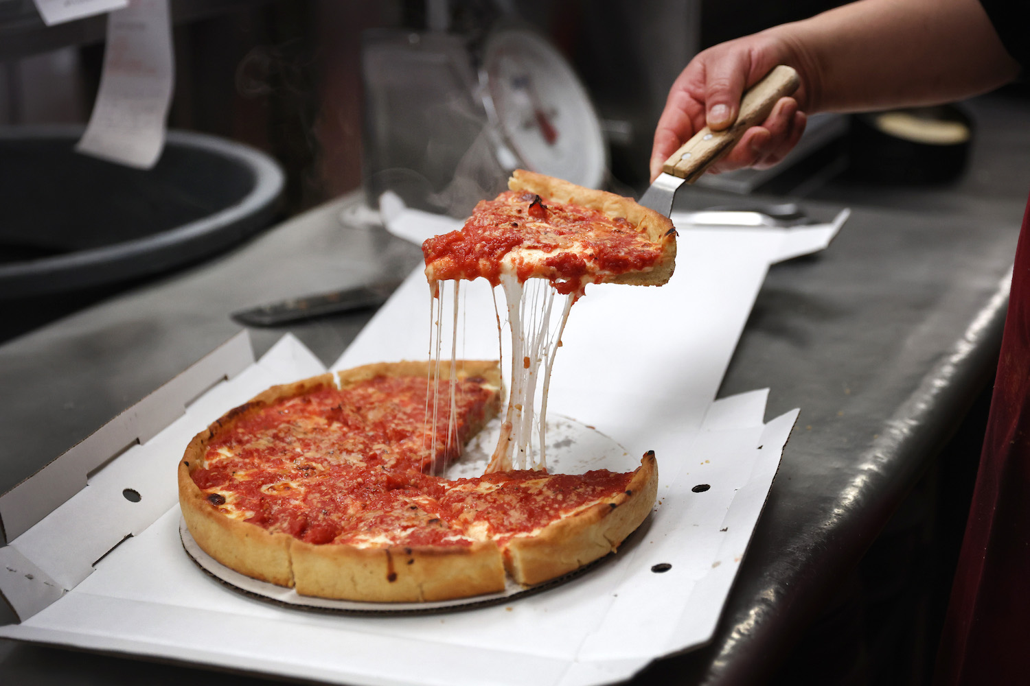 A worker prepares a Chicago-style deep dish pizza at a Lou Malnati's restaurant
