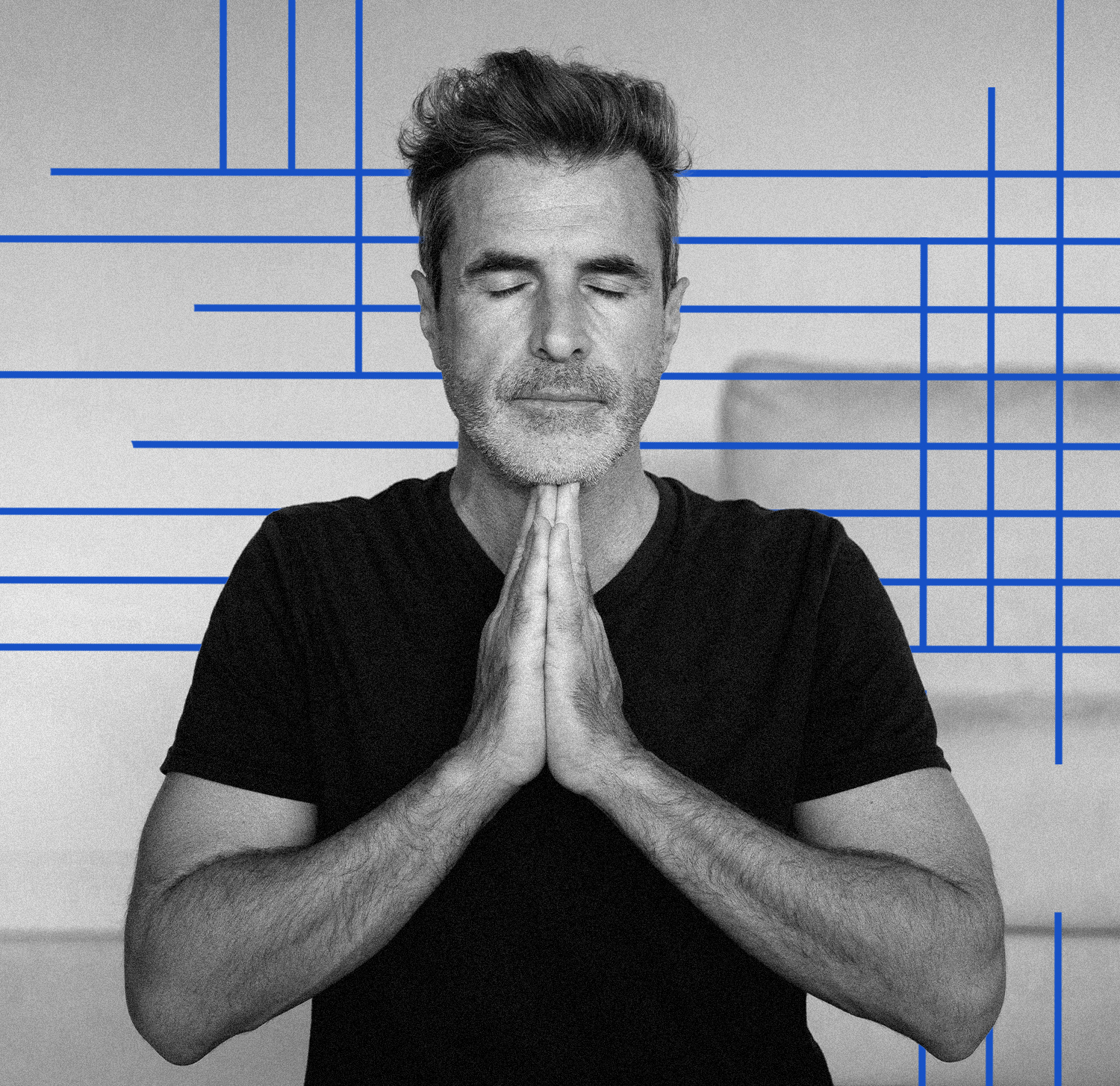 Middle-aged man standing with eyes closed and hands in a prayer position before a Pilates session.